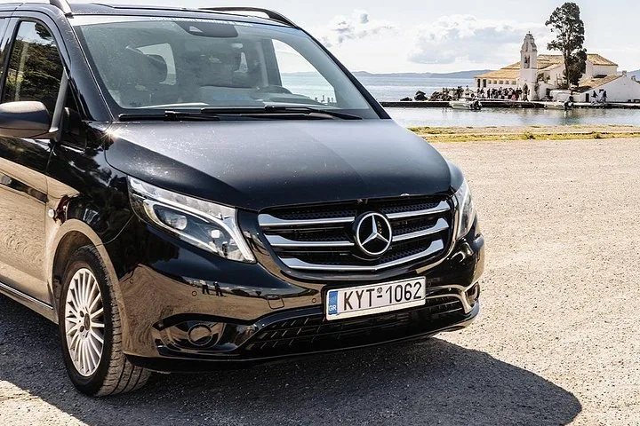 Close-up of a black Mercedes van parked with a coastal background