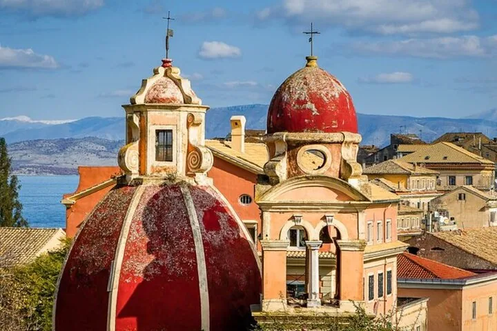 Historic church domes painted in red and beige standing prominently in a town