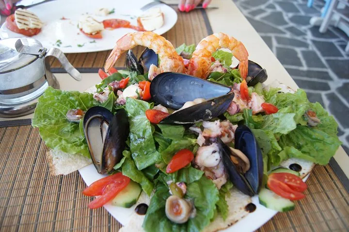 Delicious seafood salad with shrimp, mussels, octopus, and fresh greens on a plate