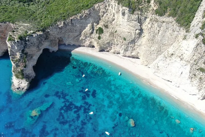 Aerial view of a stunning hidden beach enclosed by towering rocky cliffs