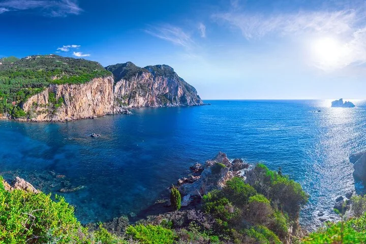 Expansive view of a deep blue sea bordered by dramatic rocky cliffs